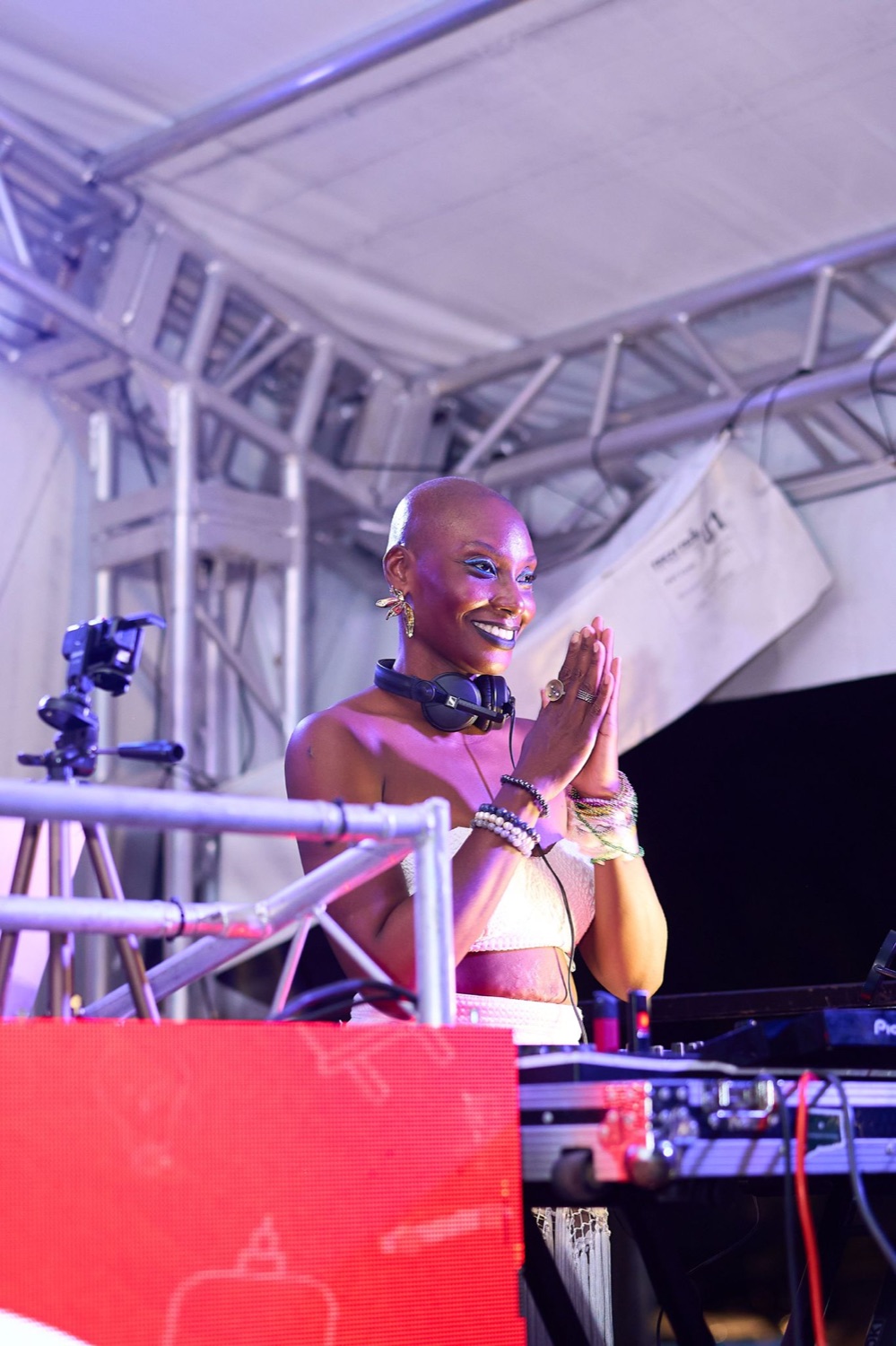 Aset of Kemet on stage, hands in prayer under stage lights